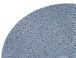 Close-up of numerous small blue-gray spherical pellets densely packed along a curved edge, like a granulated material. read more? (informative)
