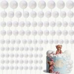 White globe string lights hang overhead above a pastel birthday cake with teddy bears on top, creating a festive backdrop, the scene soft and whimsical.