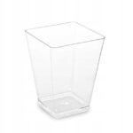 34ca7f4284fd08c78049d4760f622048jpg › Udanewypieki Clear square plastic cup with rounded corners and a flat base on a white background, empty and transparent.
