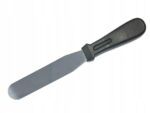 86f03e86d87976cb8c40afd8411e9a2fjpg › Udanewypieki Metal icing spatula with a flat wide blade and black handle, used for spreading frosting on cakes.
