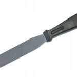 Metal icing spatula with a flat wide blade and black handle, used for spreading frosting on cakes.