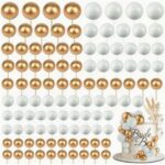 Gold and white pearl balloon garland backdrop with a small wedding cake on the right side.